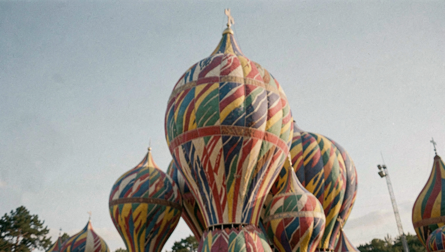 Groupe de coupoles en bulbe aux motifs colorés et torsadés se détachant sur un ciel dégagé d'hiver, lumière basse venue de la gauche